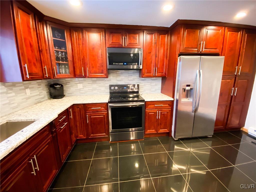 5901 Decker Road Bushkill, PA 18324 - Photo 7 of 49 a kitchen with granite countertop a refrigerator and a sink