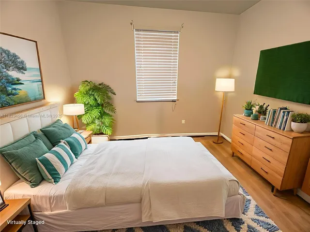 a bedroom with a bed mirror and window