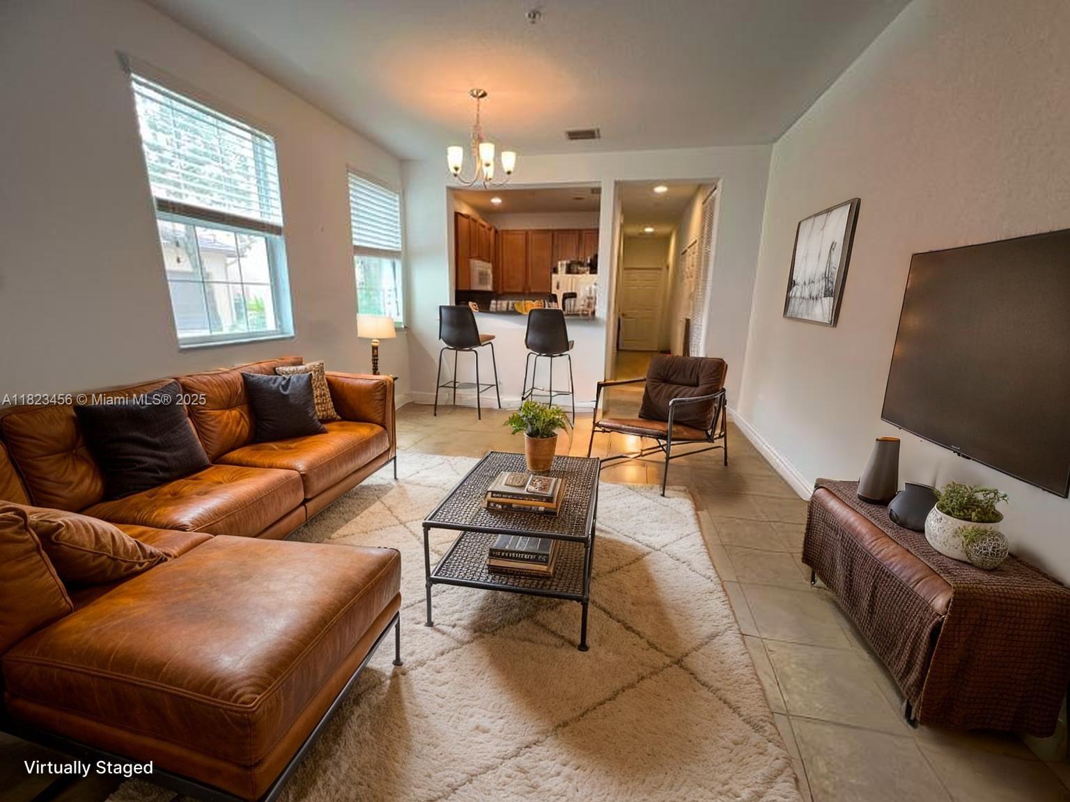 14745 Southwest 9th Street, Unit 3109 Pembroke Pines, FL 33027 - Photo 2 of 27 a living room with furniture and a flat screen tv