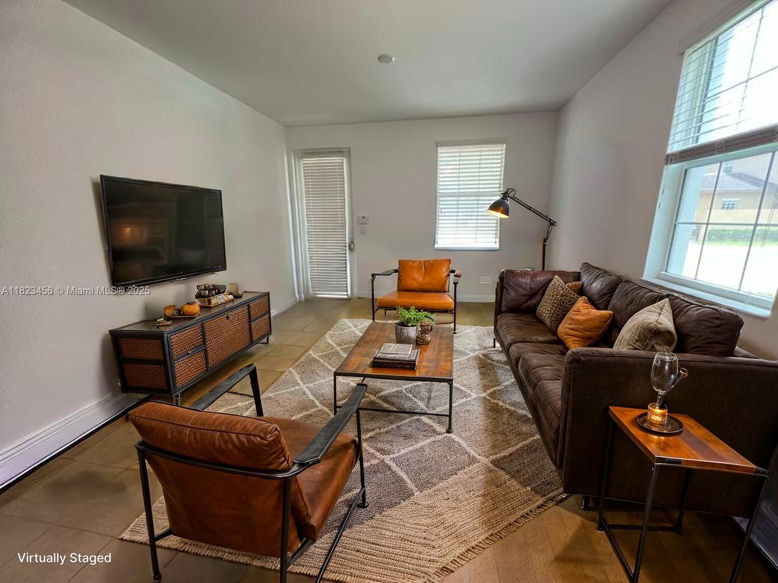 14745 Southwest 9th Street, Unit 3109 Pembroke Pines, FL 33027 - Photo 7 of 27 a living room with furniture and a flat screen tv