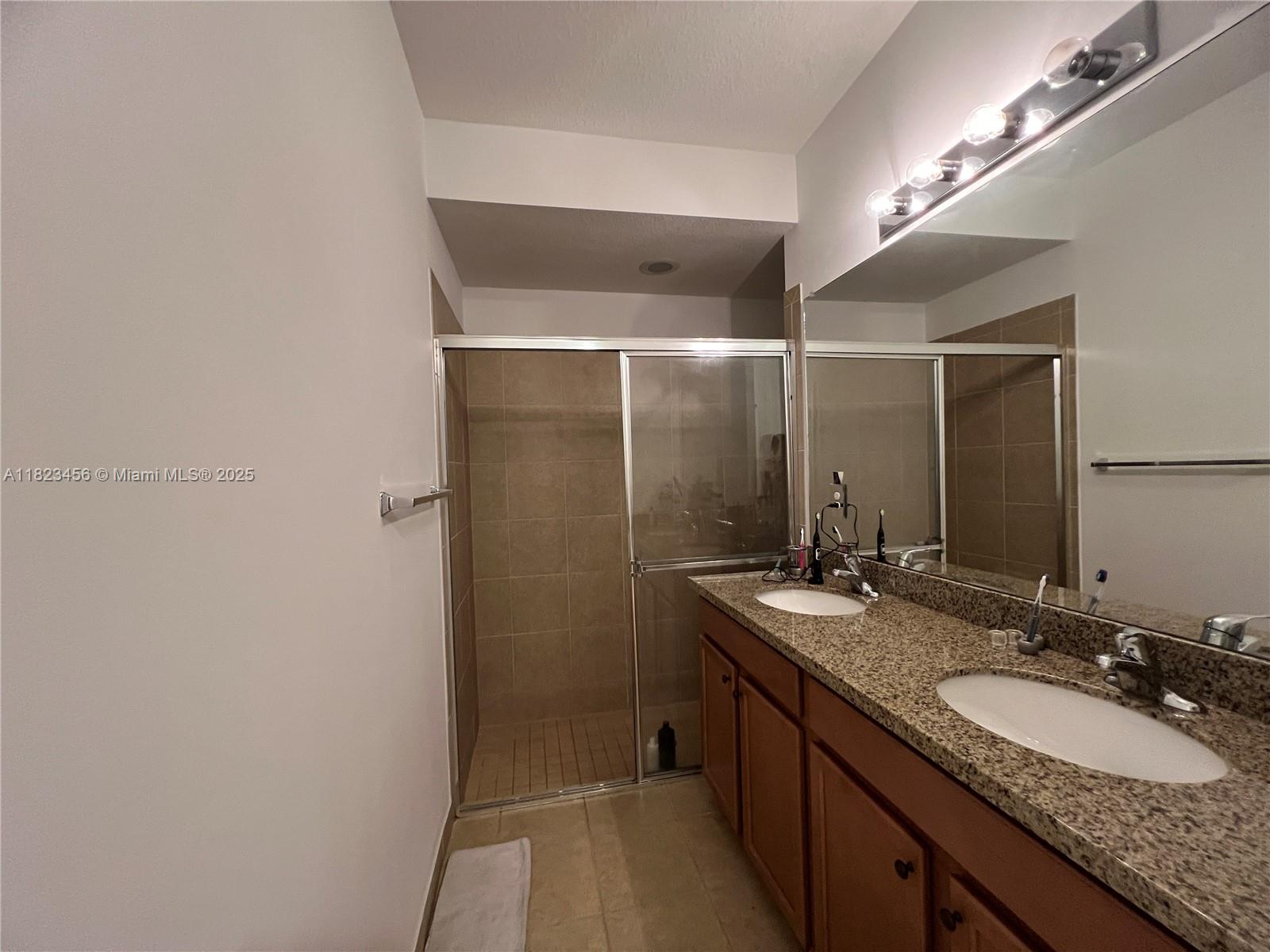 14745 Southwest 9th Street, Unit 3109 Pembroke Pines, FL 33027 - Photo 10 of 27 a bathroom with a granite countertop sink and a mirror
