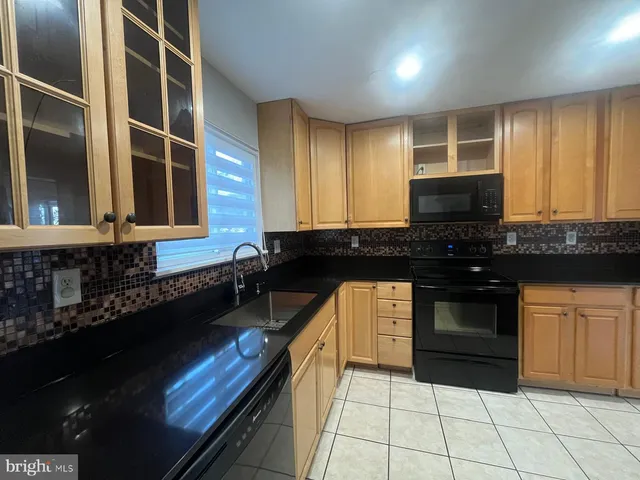 a kitchen with granite countertop a stove a sink and a microwave