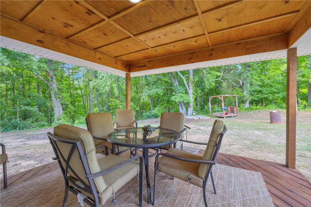 3030 Smith McGee Road Iva, SC 29655 - Photo 24 of 46 Enjoy tranquil woodland views from this inviting covered deck, perfect for outdoor relaxation.