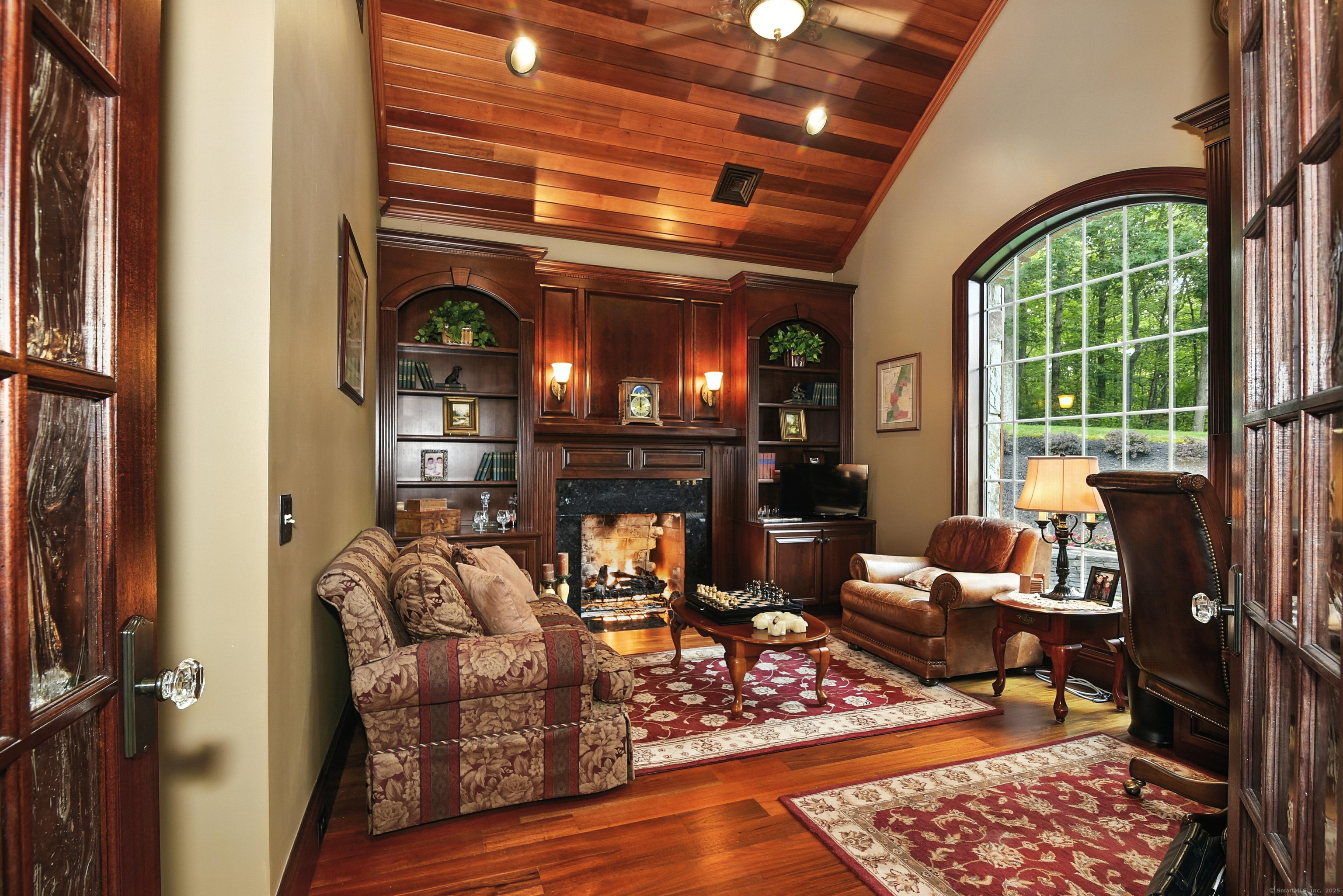 282 Searles Road Pomfret, CT 06259 - Photo 8 of 40 Brazilian mahogany and seeded glass French doors open to the office. Gas/wood-burning fireplace is surrounded by black marble and custom cherry raised panels, mantle, and 9-foot tall custom cabinets.