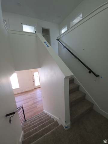 1267 West 2350 South Perry, UT 84302 - Photo 10 of 20 Carpeted stairway with a dark handrail and white balustrade