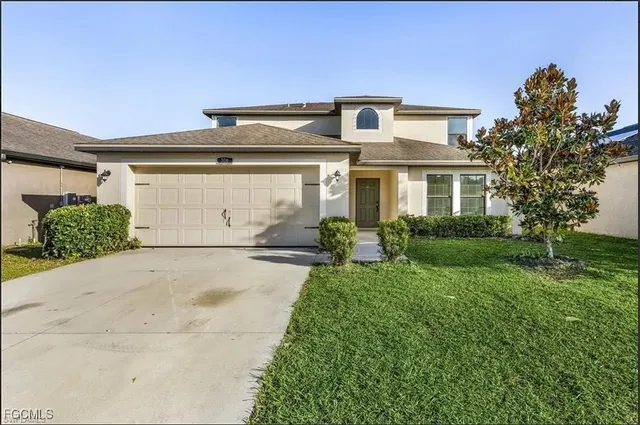 a front view of a house with a yard and garage