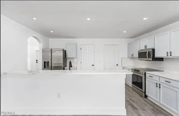 a large kitchen with stainless steel appliances granite countertop a stove a sink and a refrigerator