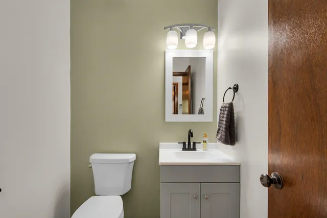a bathroom with a toilet sink and mirror