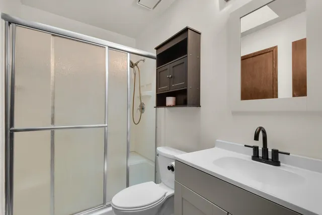 a bathroom with a sink a toilet and shower