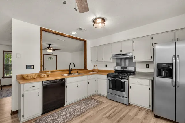 a kitchen with stainless steel appliances granite countertop a sink stove oven and refrigerator