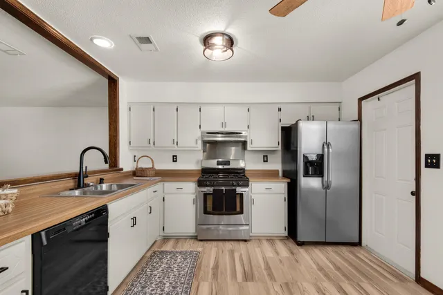 a kitchen with stainless steel appliances a refrigerator sink and cabinets