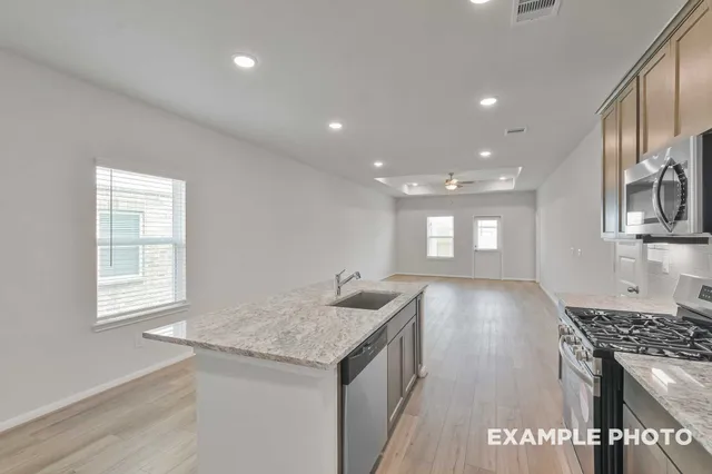 a kitchen with kitchen island a sink stove and cabinets