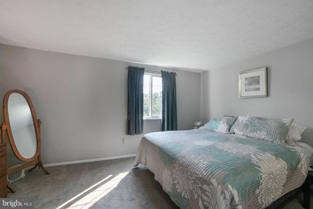 a bedroom with a bed a mirror and lamp