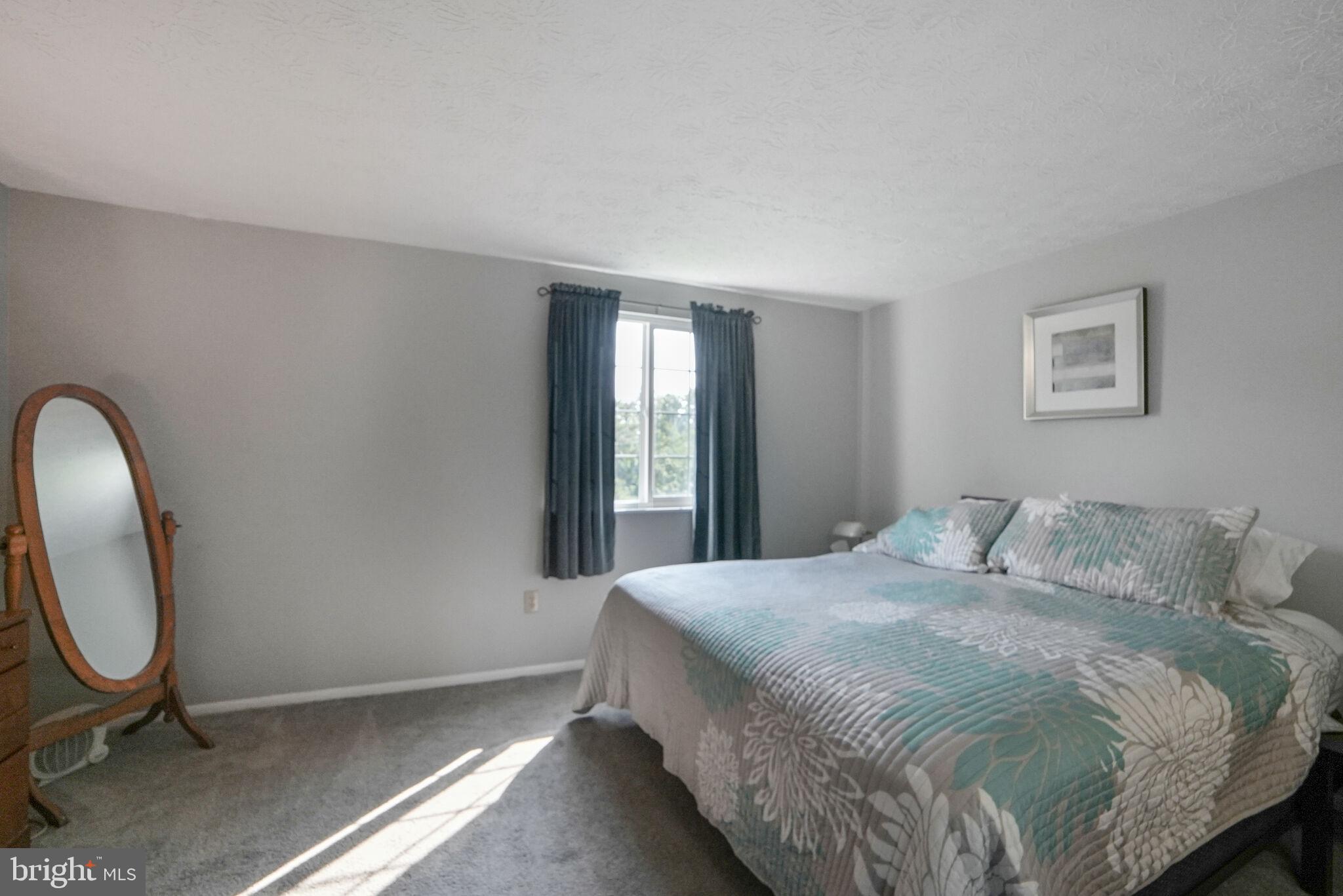 3650 Castle Terrace, Unit 11112 Silver Spring, MD 20904 - Photo 9 of 26 a bedroom with a bed a mirror and lamp