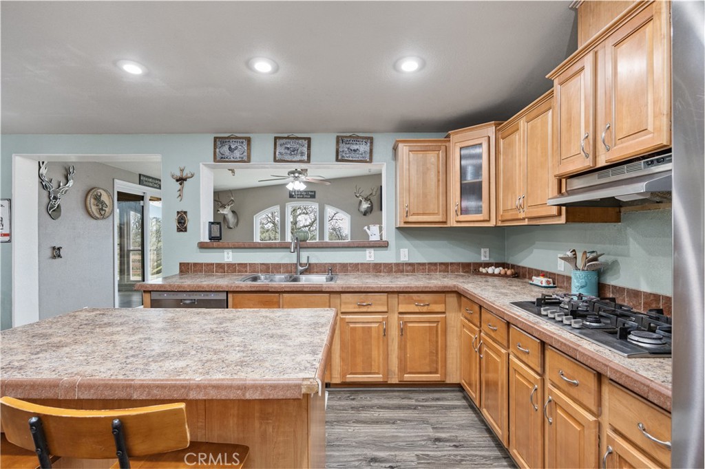 42100 Buckeye Street Caliente, CA 93518 - Photo 31 of 64 a kitchen with stainless steel appliances granite countertop a stove a sink dishwasher and cabinets with wooden floor