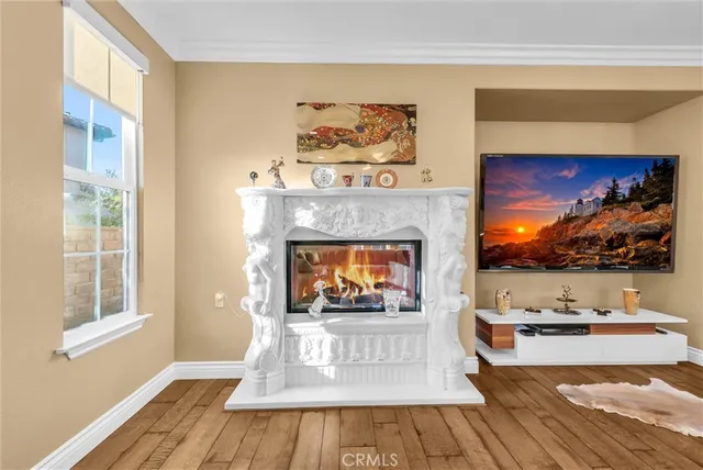 a kitchen with stainless steel appliances granite countertop a stove top oven a sink dishwasher and white cabinets with wooden floor