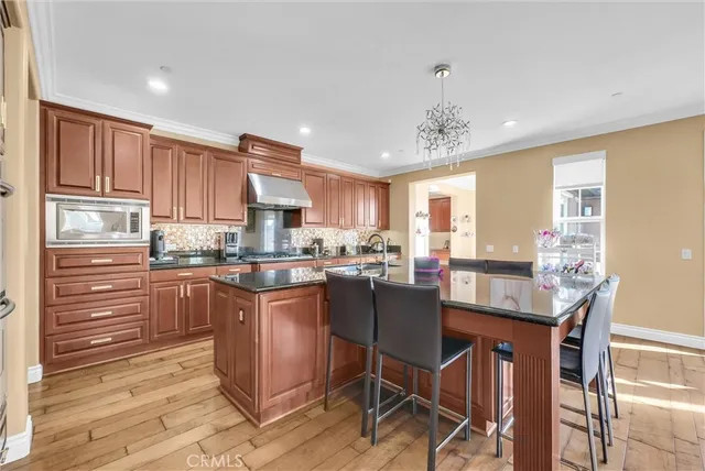 a kitchen with stainless steel appliances granite countertop a refrigerator and wooden cabinets