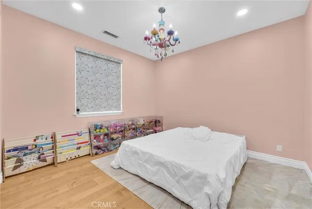 a bedroom with a bed and a chandelier