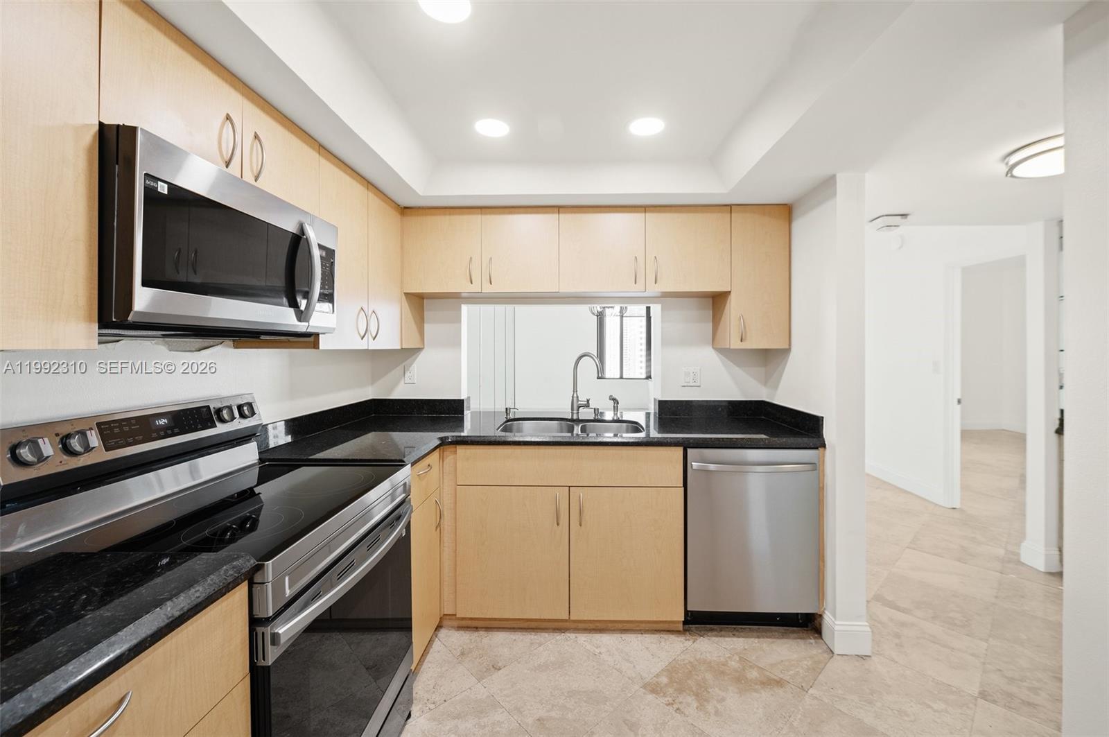 520 Brickell Key Drive, Unit A1712 Miami, FL 33131 - Photo 12 of 34 a kitchen with stainless steel appliances granite countertop a stove microwave and sink