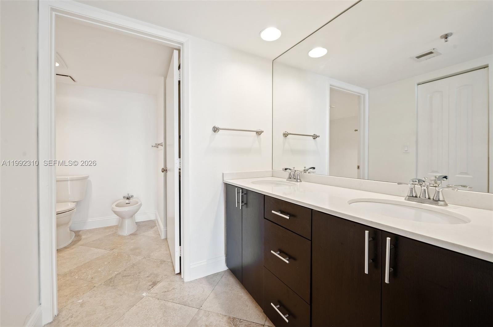 520 Brickell Key Drive, Unit A1712 Miami, FL 33131 - Photo 18 of 34 a spacious bathroom with a granite countertop sink toilet and shower