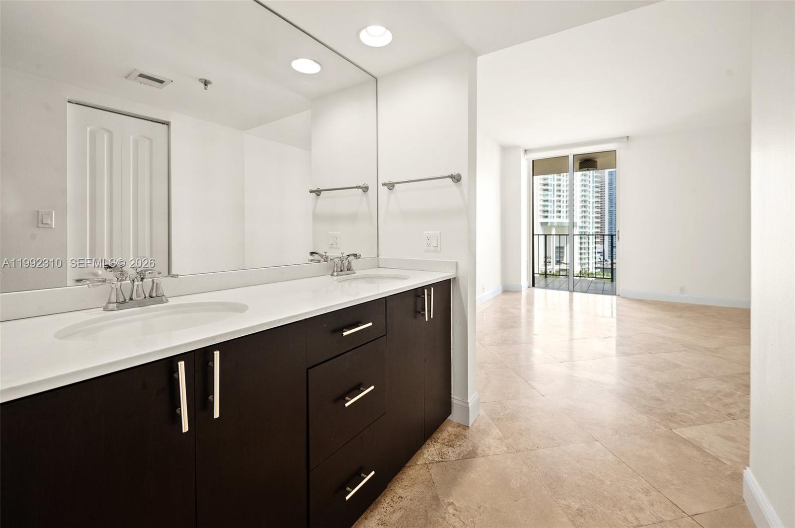 520 Brickell Key Drive, Unit A1712 Miami, FL 33131 - Photo 21 of 34 a bathroom with a double vanity sink a large mirror and shower