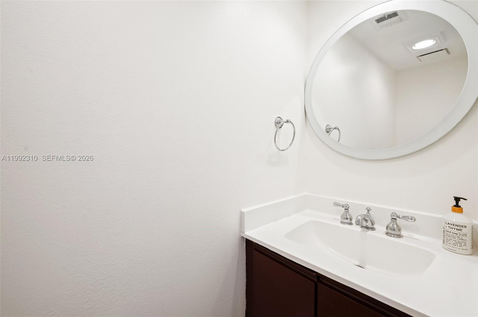 520 Brickell Key Drive, Unit A1712 Miami, FL 33131 - Photo 25 of 34 a bathroom with a sink vanity and a mirror