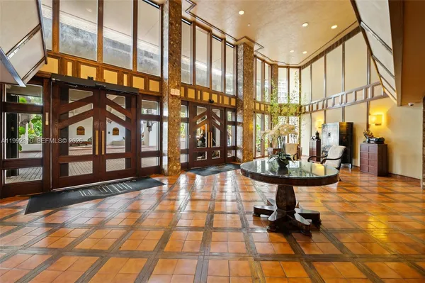 a room with lots of tables a large window and chairs