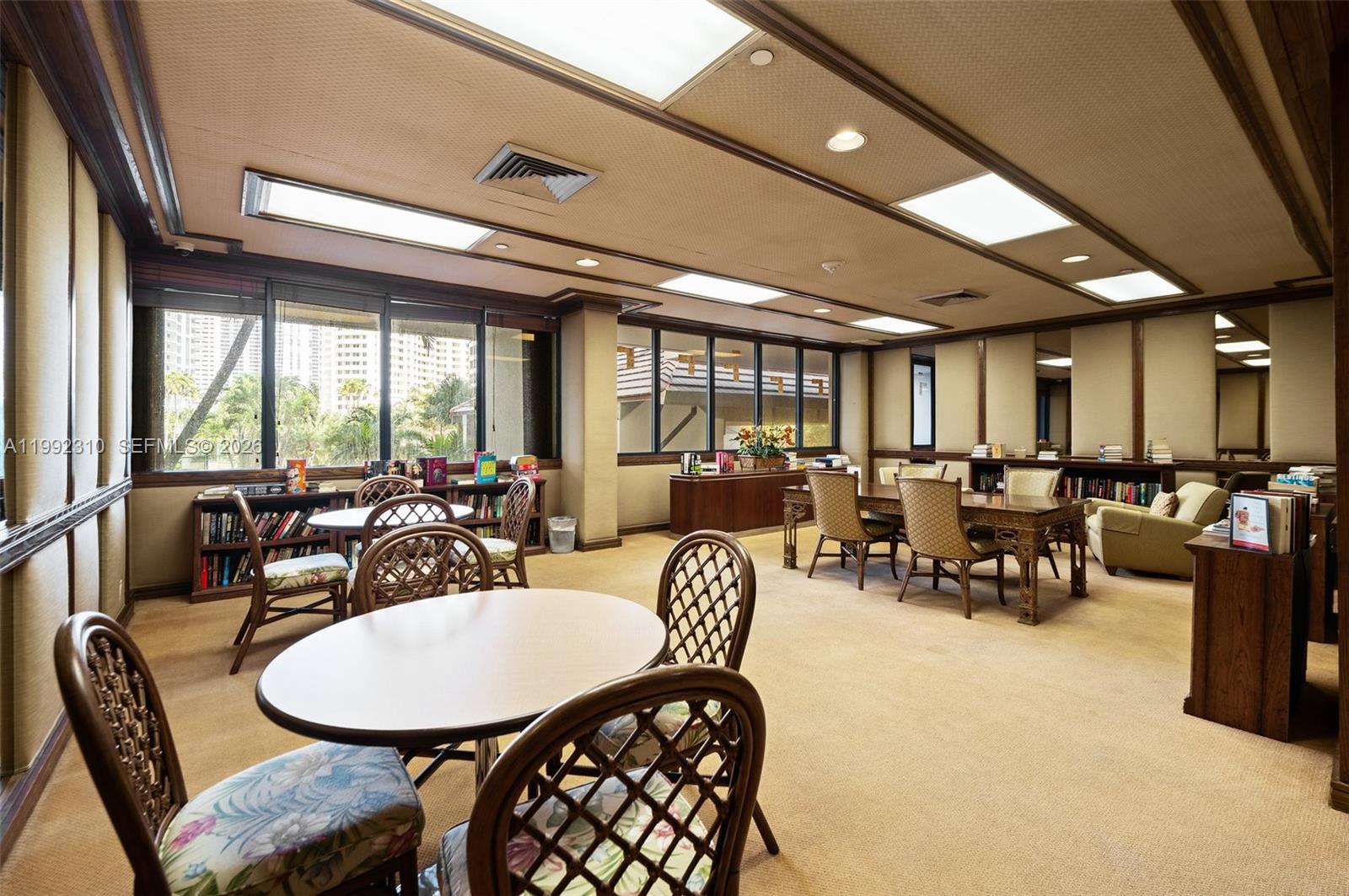 520 Brickell Key Drive, Unit A1712 Miami, FL 33131 - Photo 32 of 34 a room with lots of tables a large window and chairs