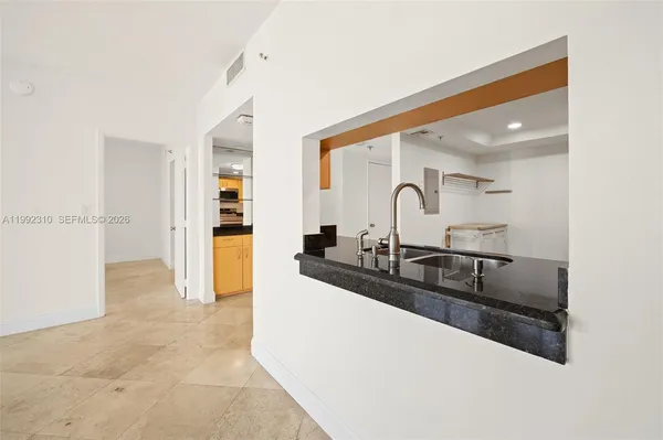 a kitchen with granite countertop a sink and cabinets