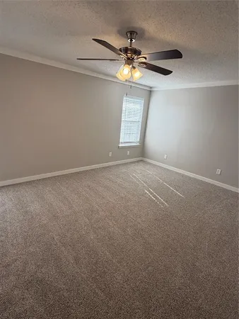a view of an empty room with a chandelier fan