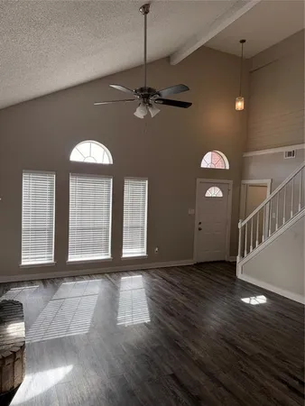 a view of a livingroom with wooden floor and a ceiling fan