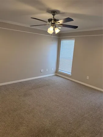 a view of an empty room with a chandelier fan