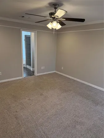 a view of an empty room with a chandelier fan