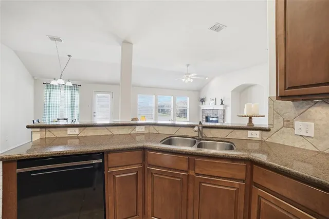 a kitchen with granite countertop a sink and cabinets