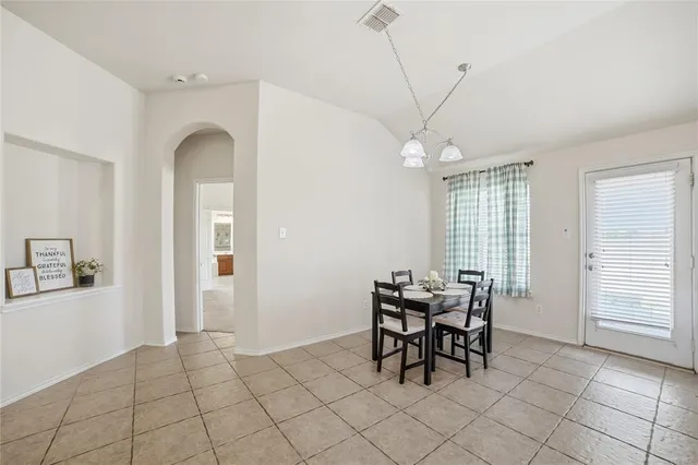 a view of a dining room with furniture and chandelier