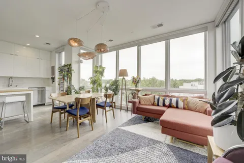 a living room with furniture fireplace and a large window