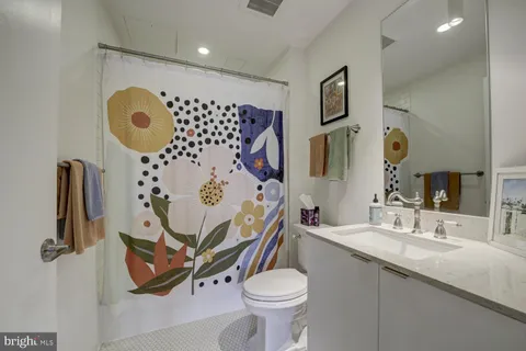 a bathroom with a sink mirror vanity and toilet