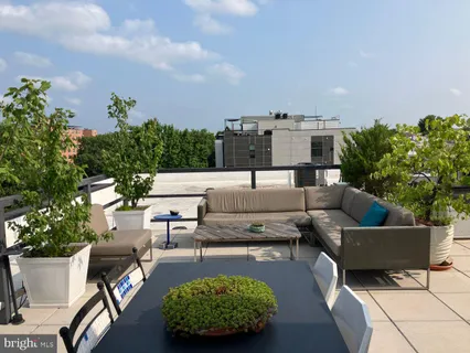 a view of a patio with couches table and chairs with potted plants and big yard