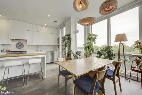 a dining room with furniture a large window and a chandelier