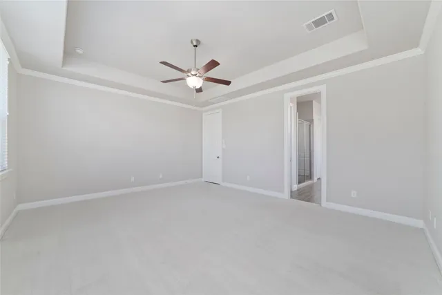 an empty room with a ceiling fan and a window