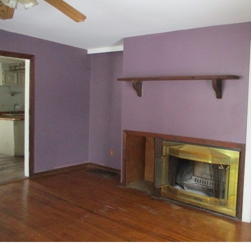 24902 Poplar Road Genoa, IL 60135 - Photo 4 of 11 a view of an empty room with wooden floor and a fireplace