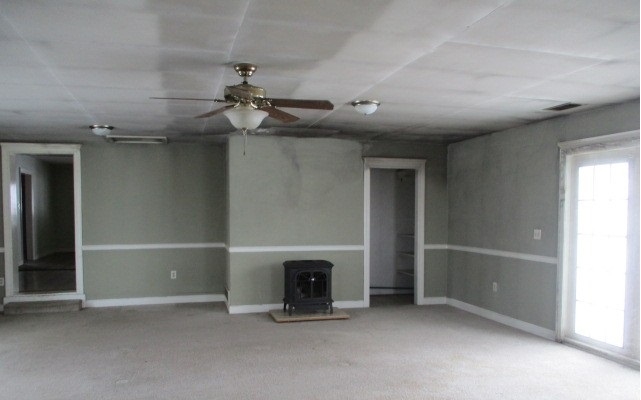 24902 Poplar Road Genoa, IL 60135 - Photo 6 of 11 an empty room with windows fireplace and fans