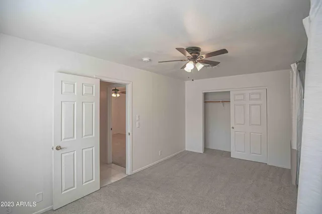 a view of an empty room with a chandelier fan