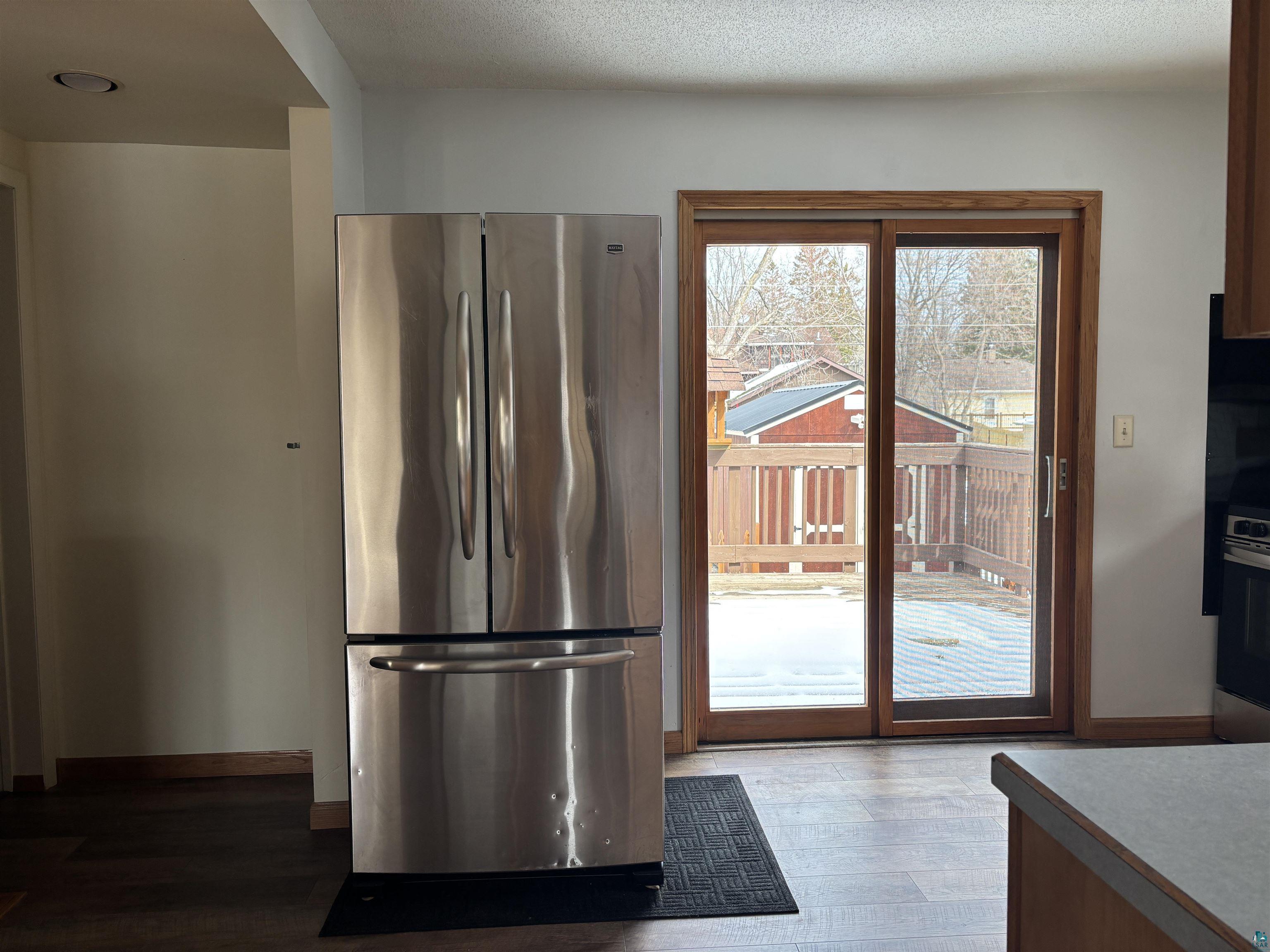 21 4th Street Proctor, MN 55810 - Photo 17 of 35 Kitchen with freestanding refrigerator, wood finished floors, a textured ceiling, range, and baseboards
