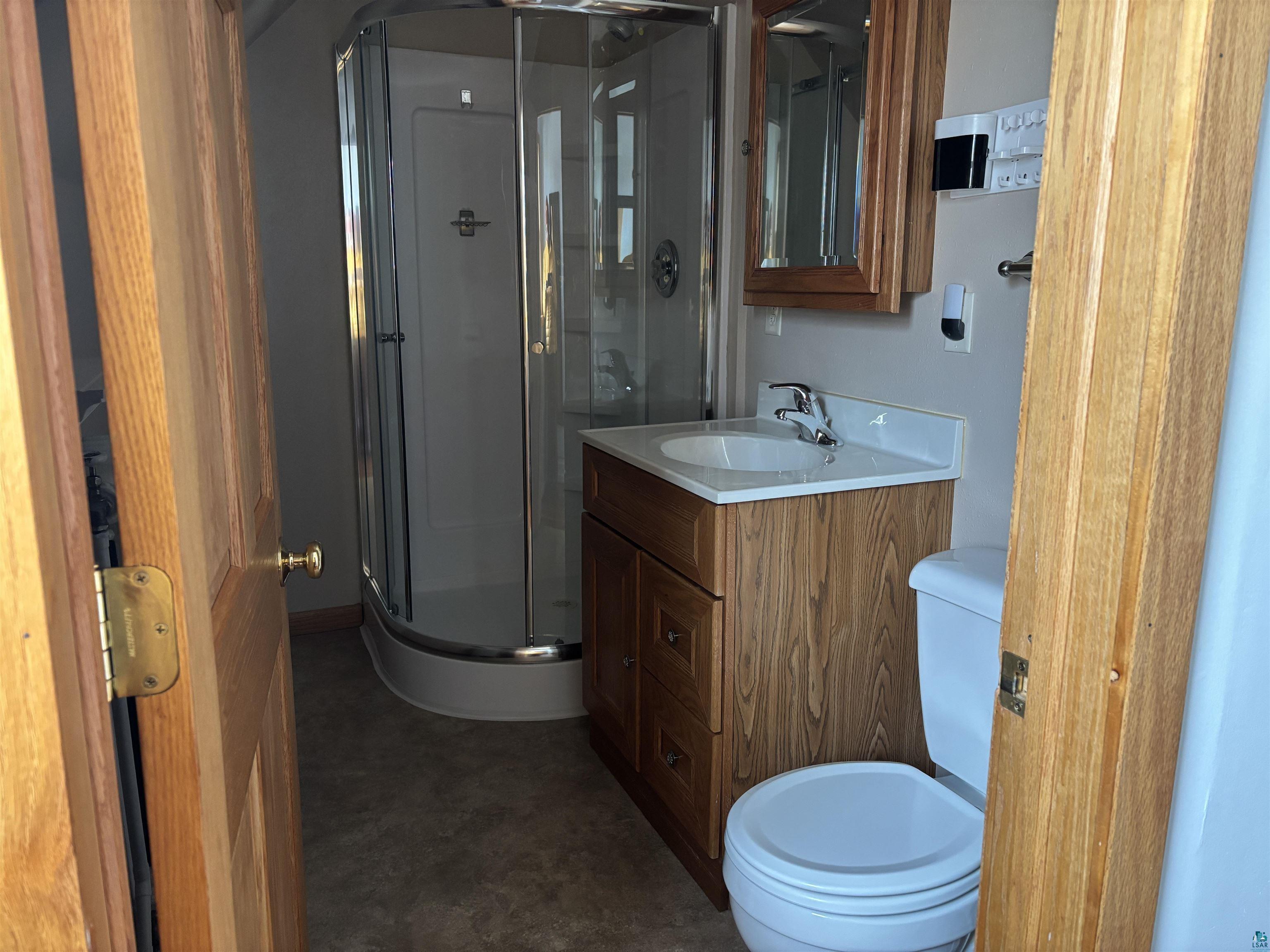 21 4th Street Proctor, MN 55810 - Photo 30 of 35 Bathroom featuring toilet, vanity, and a stall shower