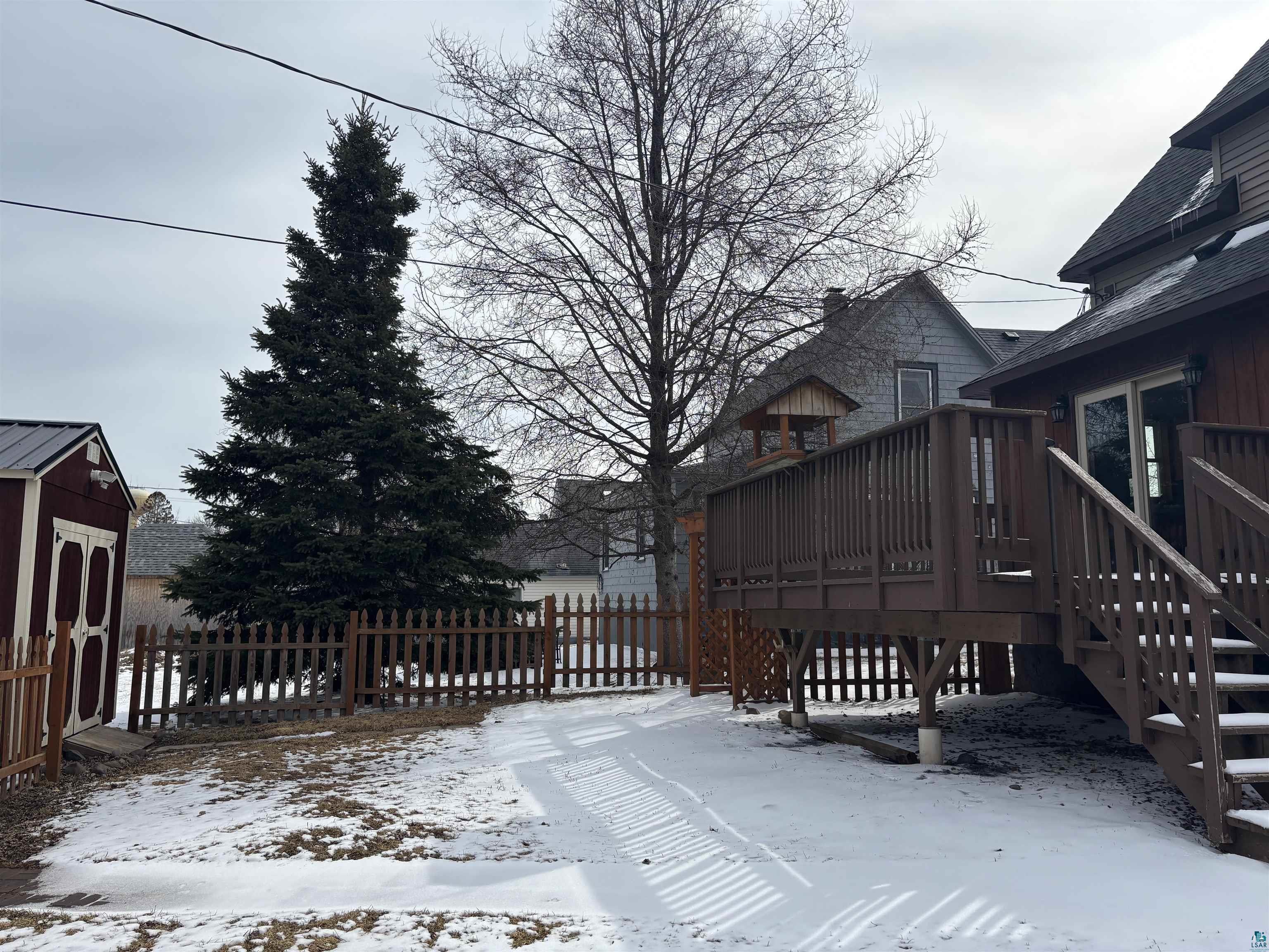 21 4th Street Proctor, MN 55810 - Photo 6 of 35 Snow covered deck featuring an outdoor structure and fence