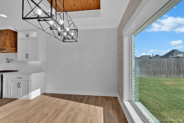 a view of a room with wooden floor ceiling fan and window