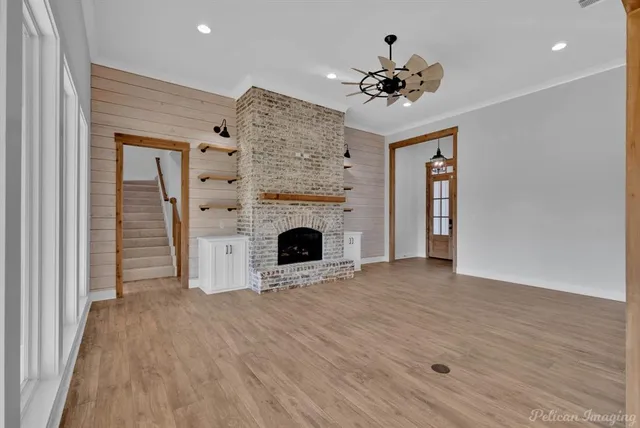 a view of a livingroom with a fireplace a chandelier and wooden floor