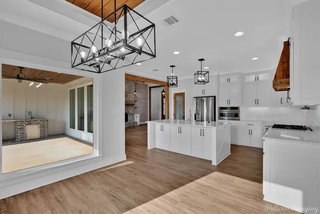a large white kitchen with lots of counter space and refrigerator
