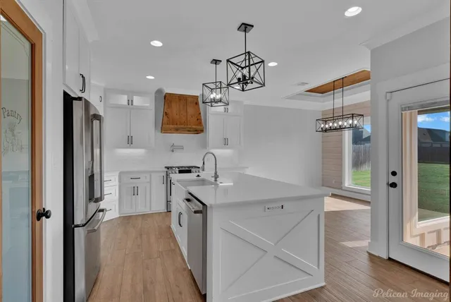 a kitchen with kitchen island white cabinets and refrigerator